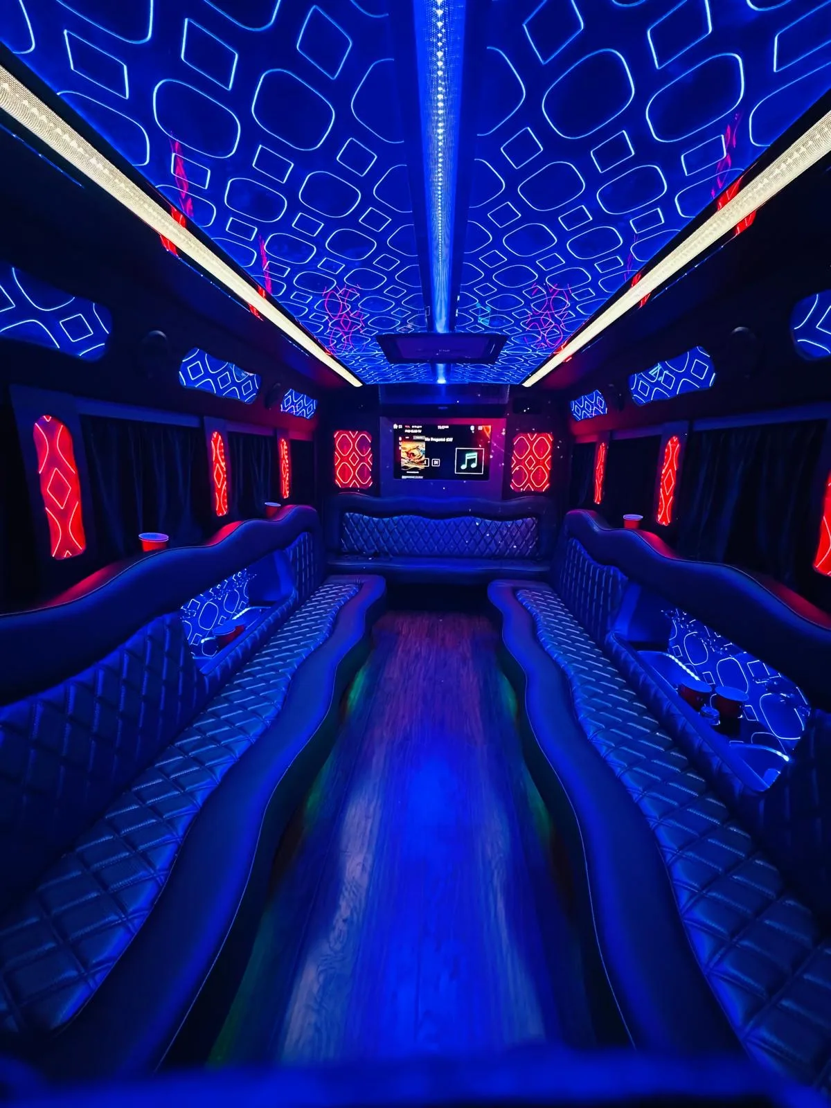 Party bus lounge seating with blue and red neon lighting