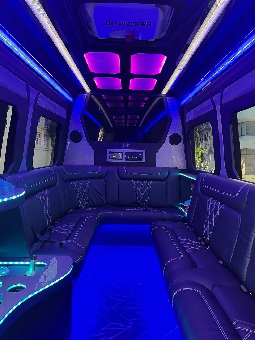 Sprinter limo facing rows of seating with purple lighting