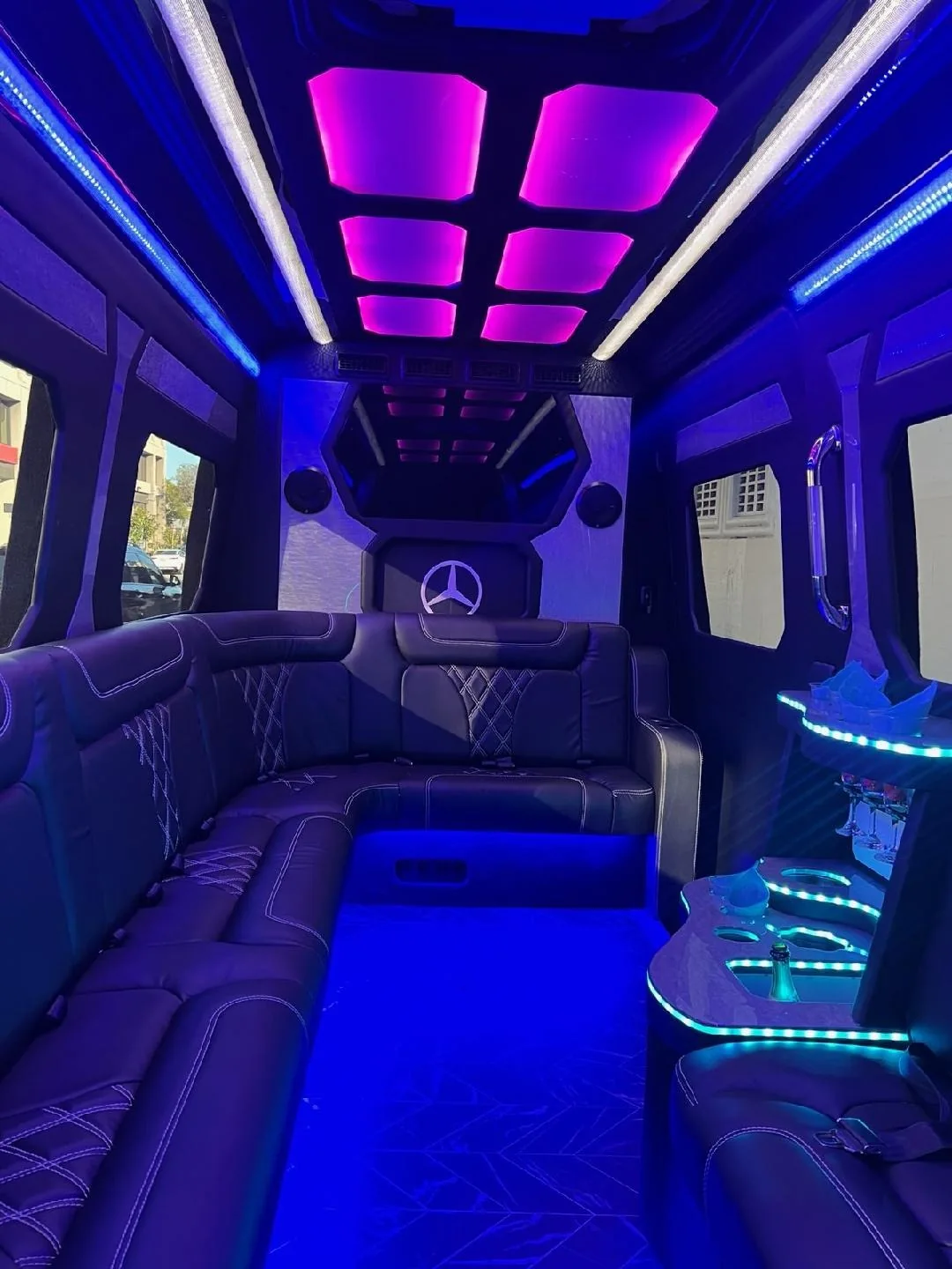 Sprinter limo lounge seating with purple ceiling lights