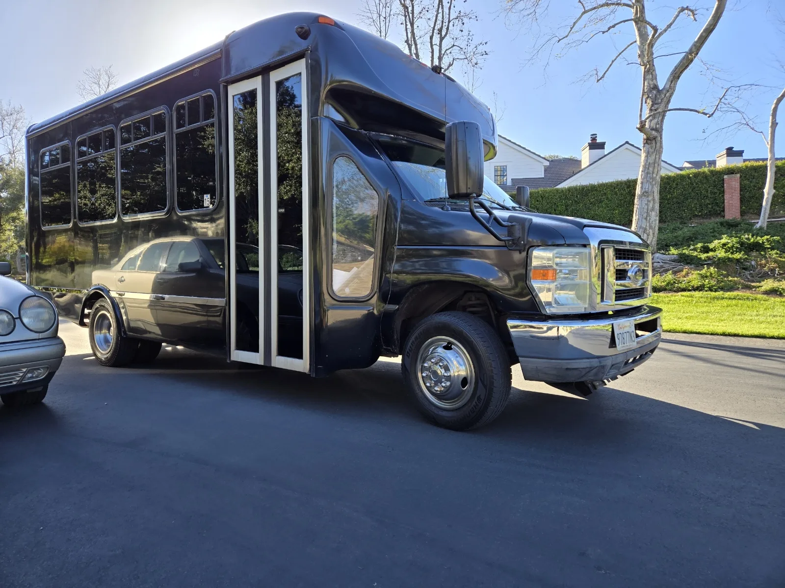 Black party bus with the door open in a driveway