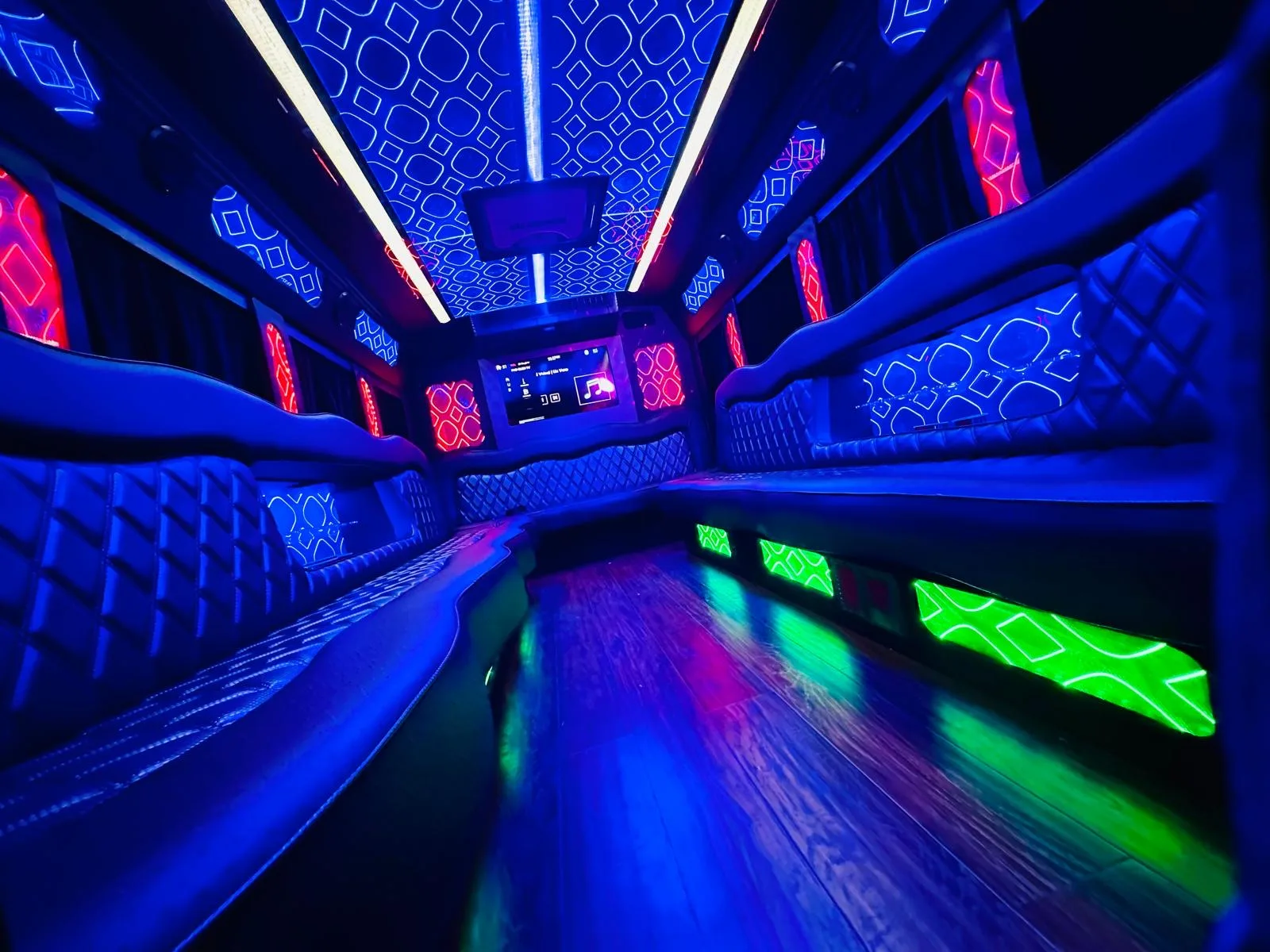 Wide party bus interior with blue ceiling and green accents