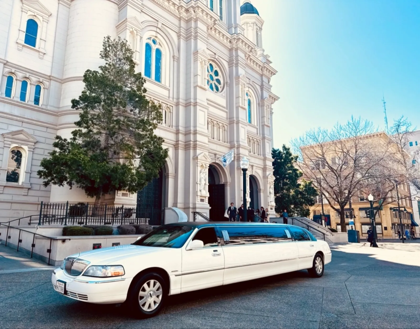 White Lincoln Town Car stretch limo outside a cathedral