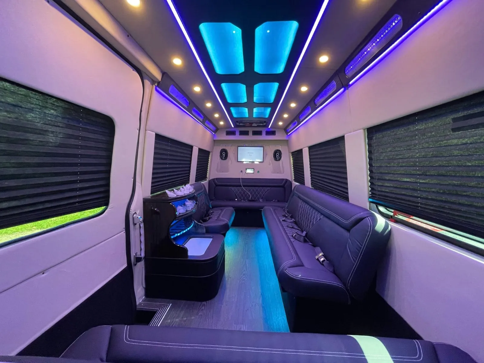 Sprinter limo lounge seating with violet mood lighting