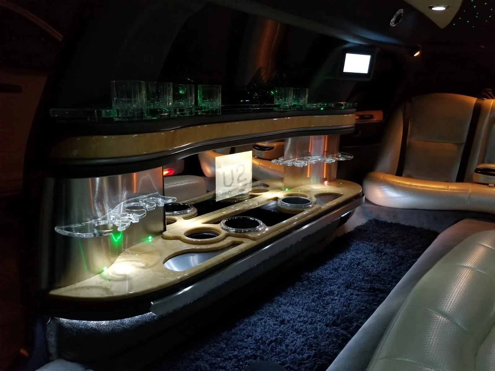 Stretch limo bar with champagne glasses and warm lighting