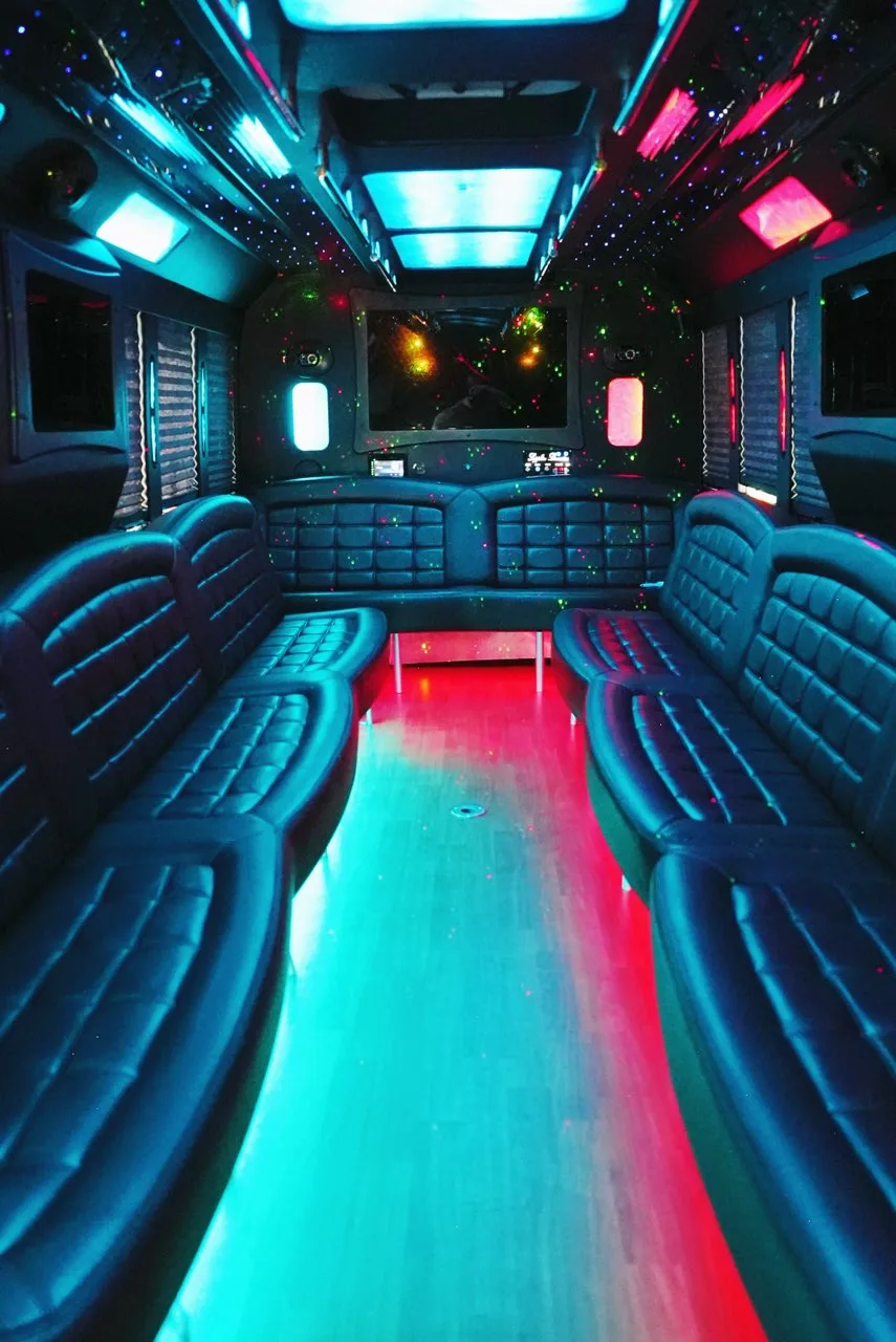 Party bus seating under teal and pink lights