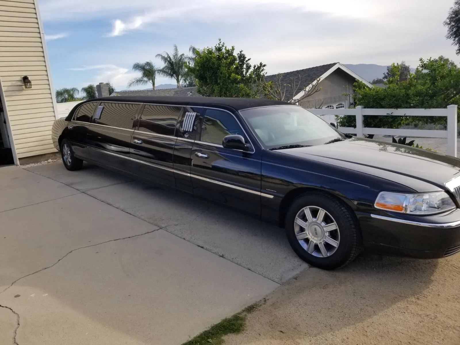Black stretch limousine parked in a driveway
